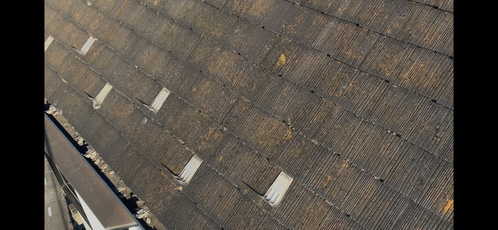 茶色い苔が発生したスレート屋根